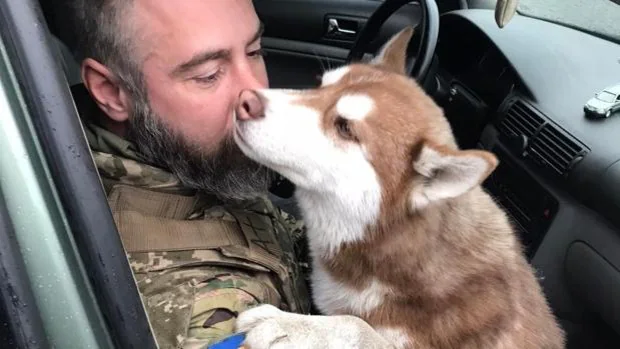 El soldado junto a la perra que ha rescatado