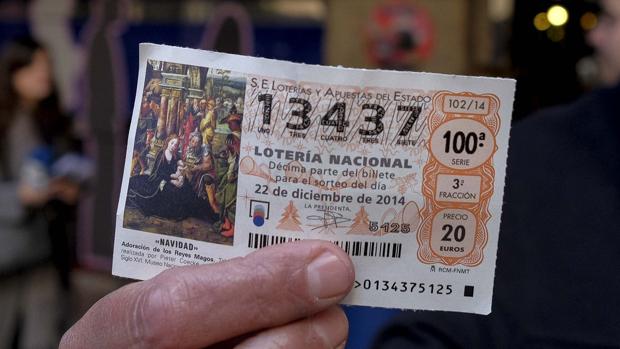 Un empleado del museo de cera de Madrid muestra un boleto de primer premio en la Lotería de Navidad de España en 2014