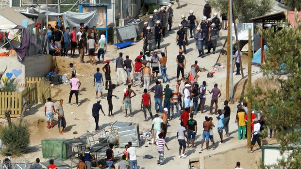 Varios refugiados huyendo del campamento instalado en Moria (isla de Lesbos, Grecia) incendidado este lunes