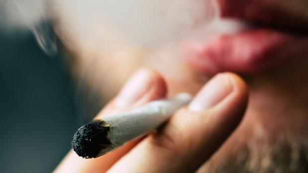 Un hombre da una calada a un cigarro de marihuana