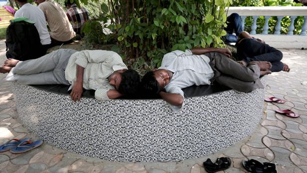 Dos viajeros descansan a la sombra en Calcuta, India