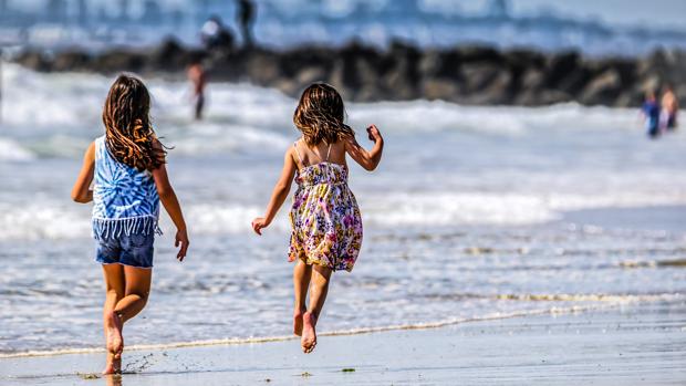 Dos niñas juegan en una playa de California