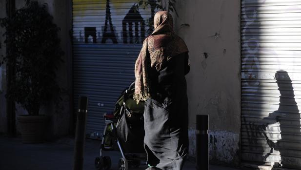 Una mujer camina por la calle vistiendo el velo islámico