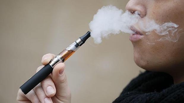 Una mujer fuma un cigarrillo electrónico