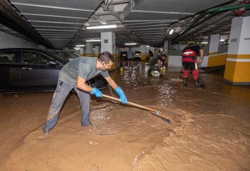 Trabajadores del Ayuntamiento de Águilas achican agua del garaje de un hotel, tras la gota fría de este jueves